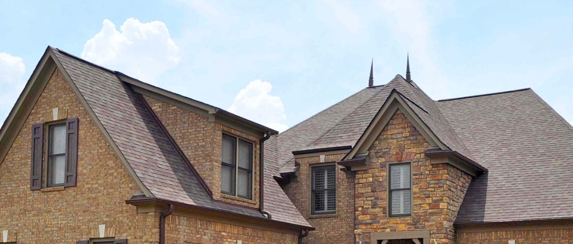 A large brown house with two windows and a roof.