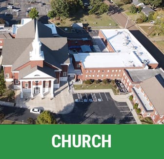 A church with a large building in the background